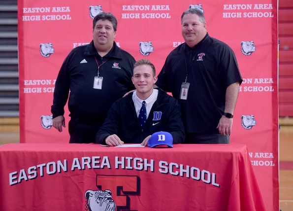 Easton High School baseball player Luke Storm signs his letter of intent for Duke University last December while surrounded by coaches Greg Hess (left) and Carm LaDuca (right). (Amy Shortell/The Morning Call)